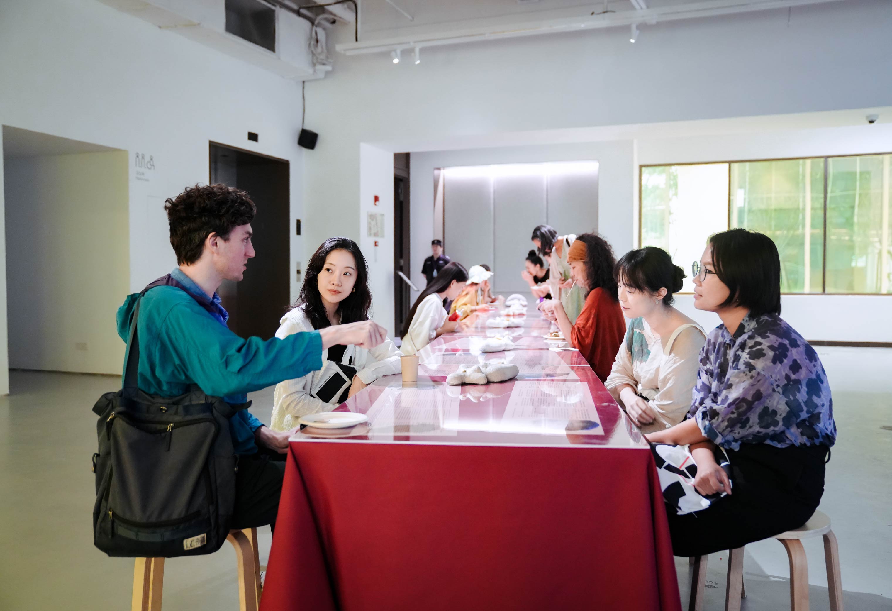 People sit across from one another at a table at an exhibition.