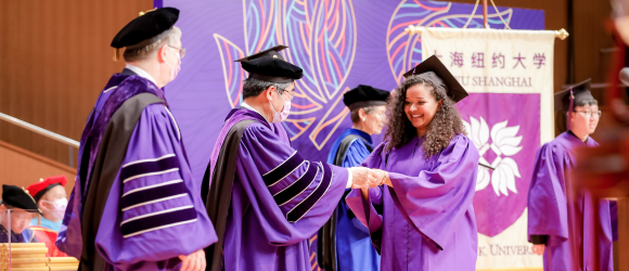 Graduate accepts diploma from Chancellor