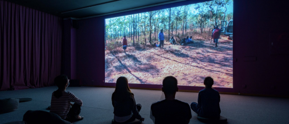 Students silhouetted against movie screen