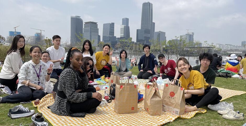 [Beyond the Magnolia House] April 15 2023, a beautiful sunny spring day, a group of 10 first-year students joined the Biking & Picnic event. The biking group biked through World Expo Park along the Huangpu River and met up with the picnic group at Qiantan Leisure Park Camping Zone (near Youcheng Park Gate 6). Students then enjoyed snacks, beverages, and McDonald’s as well as playing fun board games and frisbees on the grass.