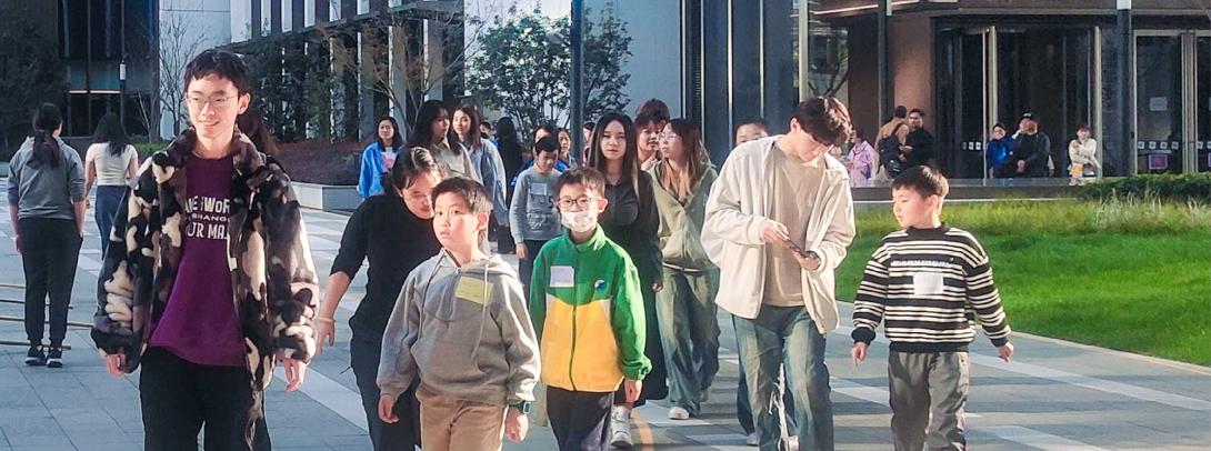 students and children walk together on campus 